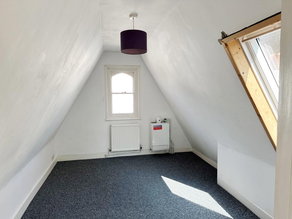 Lot: 113 - ONE-BEDROOM TOP FLOOR FLAT WITH SHARE OF FREEHOLD - Bedroom with boiler to the end of the room